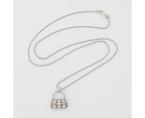 18k white gold and diamond purse form pendant. Rendered in filigree and set with nine full cut diamonds. The purse hinged to 