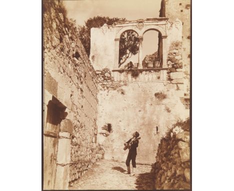 Wilhelm von Gloeden (German, 1856-1931). Albumen print photograph titled "Serenata," depicting a woman peering down through a