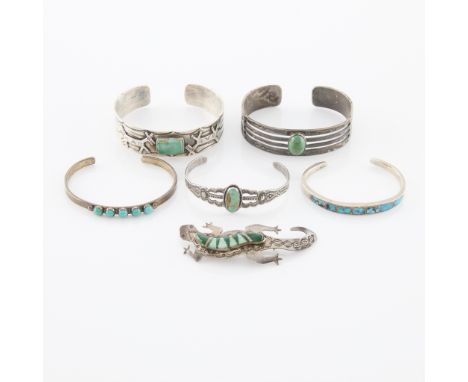 Group of five pieces of Southwest jewelry including:One silver cuff with feather, arrow, and whirling log details set with ov
