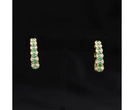 18k yellow gold hoop earrings. Each set with 12 round brilliant cut diamonds and seven round cut emeralds, graduating in size