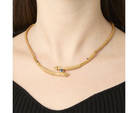 22k yellow gold necklace comprised of a substantial wheat chain and central tubular element in the bypass style. Set with cen