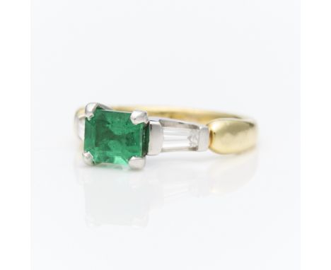 18k yellow gold ring with white gold mounting suspending a central rectangular step cut emerald, set east-west, approximately