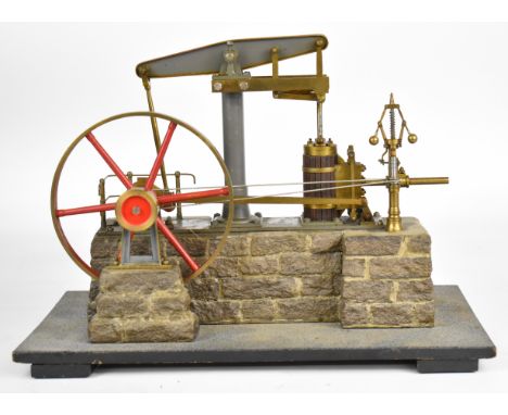 Live steam beam engine with spoked flywheel and working governor, on faux stone base with handrails around the crank, overall