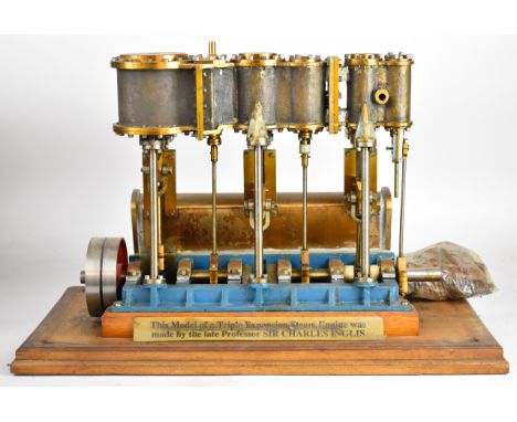 Sir Charles Inglis triple expansion live steam marine engine with condenser housing to rear, with turned flywheel, on wooden 