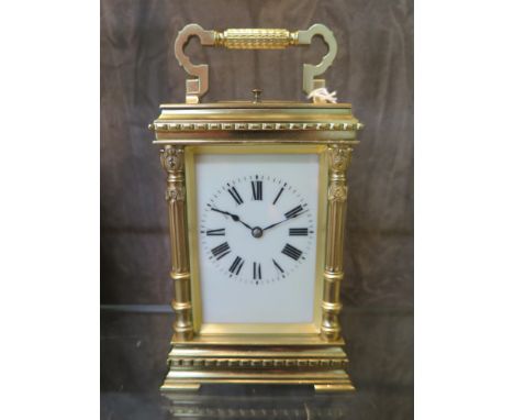 A gilt brass carriage clock, with foliate fluted columns and cream enamelled dial, the twin train movement with repeat mechan