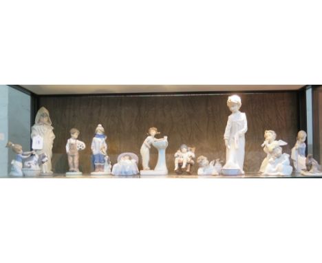 Ten Lladro figures, including a boy sleeping in bed with a puppy, another of a girl at a sink, and other child and angel figu