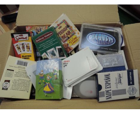 A box of vintage and modern playing cards including Railway posters, Teddy bear, Simpsoms etc 