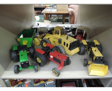 A shelf of Tonka tin plate agricultural and construction machines