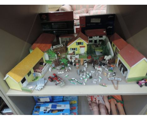 A shelf of Britains and similar plastic and diecast farm animals, workers and machinery along with wooden yards and buildings