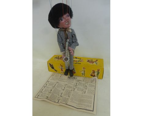 A boxed Pelham Puppet - Pop Singer no. 1, a saxophonist in striped outfit based on one of the Beatles, with instructions and 