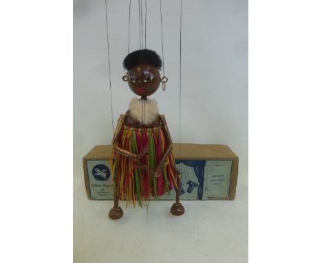 A boxed Pelham Puppet: Mumbo, mid 1950s, with brass rings on feet, original raffia, original stringing and earrings. 