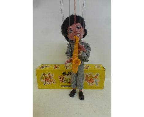 A boxed Pelham Puppet - Pop Singer no. 3, a saxophonist in striped outfit based on one of the Beatles, with instructions and 