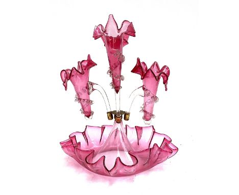 A cranberry glass epergne centrepiece, with three stemmed vases, the fourth missing, 35cm high 