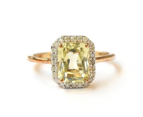 A 9ct gold ring set with hiddenite surrounded by diamonds, the octagonal hiddenite approx. 2.9cts, size P 1/2, 2.7g