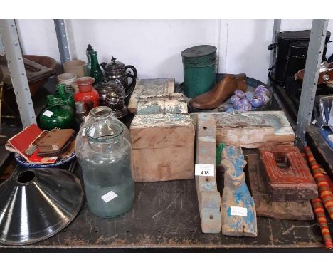 Shelf of wooden moldings, teapots, earthenware etc