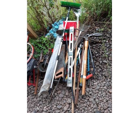 Various garden tools to include rakes, a pick axe, long handled shears, saw etc
