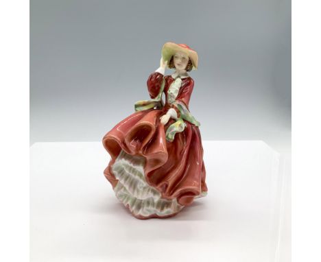 A glossy figure of a woman wearing a red dress with a petticoat, a wide brim red hat with a purple bow that she is holding on