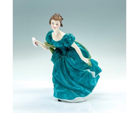 A figure of a lady in a turquoise-color gown with a green sash shawl. She is holding a white wreath with red flowers. Royal D