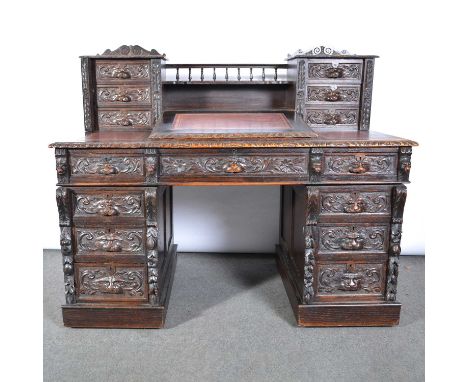 Victorian carved oak desk, superstructure with piers of three drawers, joined by a shelf with a balustrade rail, writing slop