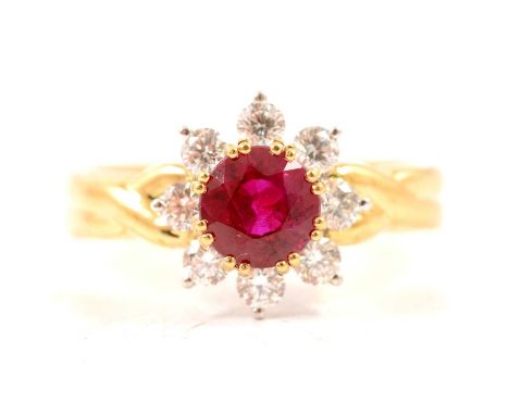 A ruby and diamond circular cluster ring, the circular faceted ruby claw set and surrounded by eight brilliant cut diamonds i