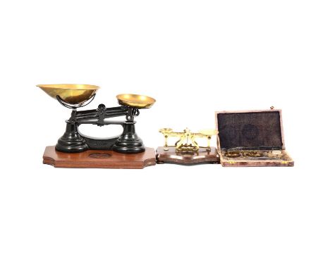 Three sets of scales, including cat iron and brass kitchen scales, postal scales and a set of scales in a case.Qty: 3