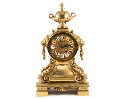 French gilt metal mantel clock, 20th Century, the case with urn finial, lion ring mask handles, scrolled base, the movement s