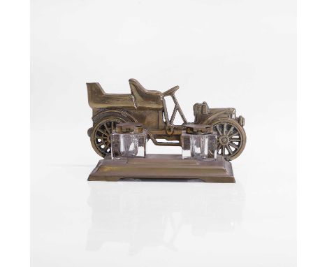 A brass-framed inkstand, c.1900, modelled as a veteran car, with glass inkwells, the base with a pen rest,15cm wide10cm highC