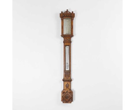 A Victorian oak Gothic stick barometer, by Negretti &amp; Zambra, with a silvered register and thermometer and carved decorat