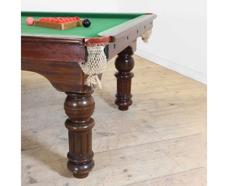 A two-thirds-size mahogany-framed slate billiard table, green baize-lined, height adjustable and on turned column legs, with 