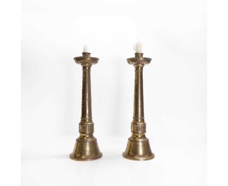 A pair of brass altar candlesticks, early 20th century, each of tapering column form with a drip pan, applied floret moulding