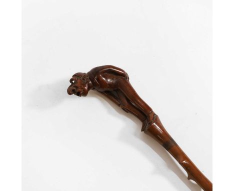 A briar walking stick, the handle carved in the form of a grotesque gentleman, with glass eyes, bending forward with one hand