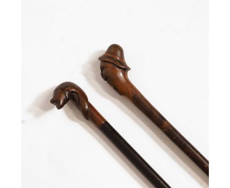 A hardwood walking stick, carved with a bearded man's face, 83.5cm long, andanother example,carved with a fish on an ebony st