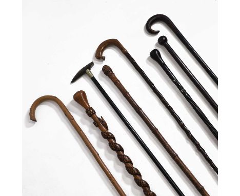 Eight walking sticks,  including a bamboo measuring cane, an ebonised stick with a horn whistle handle, an ebony stick with t
