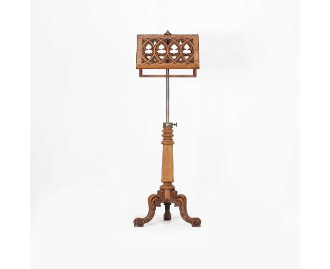 A Victorian oak music stand, with pierced Gothic tracery, adjustable rests on an adjustable brass column, and a panelled and 