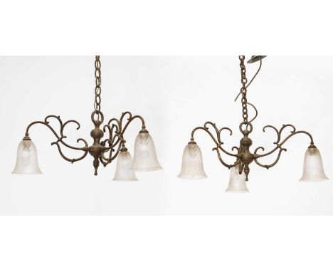 A pair of Edwardian brass ceiling lights, early 20th century, each with three scrolled arms and moulded clear shades,55cm dia