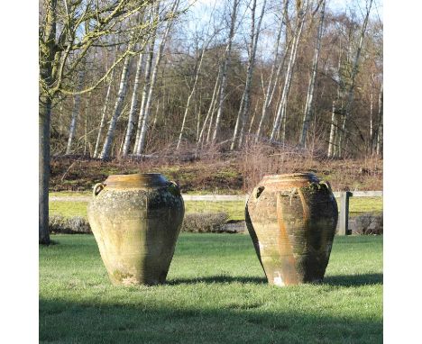 A pair of terracotta olive jars,  20th century, each of amphora shape with a glazed neck and handles, 56cm wide 79cm high (2)
