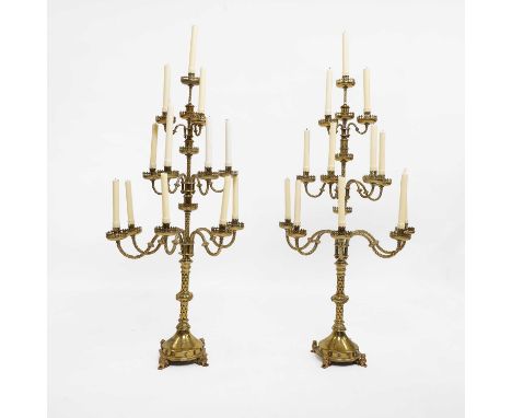 A pair of large Gothic-style brass candelabra, in the manner of AWN Pugin, each with a central sconce over nine scrolled arms