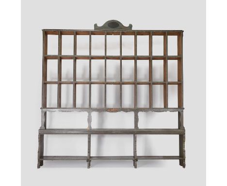 A painted pine shop display shelf, 19th century, Continental, with a central pediment, twenty-seven shelf compartments, above