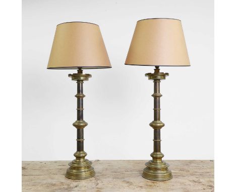 A pair of large Victorian brass altar sticks, each of knopped form with pierced decoration, on a circular stepped base, conve