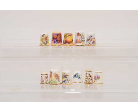 A group of ten hand painted porcelain thimbles, one by Royal Worcester and painted by S. Waldron with fruits, seven by Dunhev