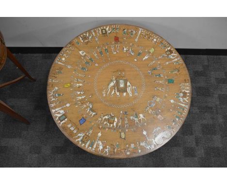 An Anglo-Indian round top coffee table with various inlays, the central scene of an elephant with a parade of bandsmen and mu