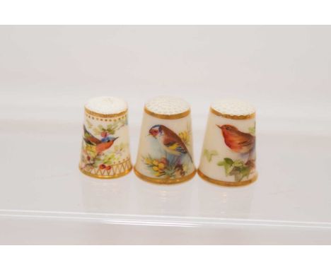 Two Royal Worcester porcelain thimbles and another, each hand painted with a bird including a Robin and a Gold finch (3)