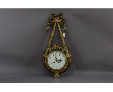 A French Empire style gilt bronze cartel clock, the case with rose and ribbon swag decoration. Eight day movement signed "Sam