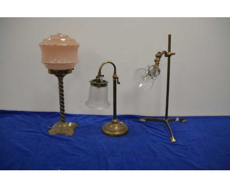 An Edwardian brass table lamp and two others, tripod base with later glass shade, another with barley twist and pink glass sh