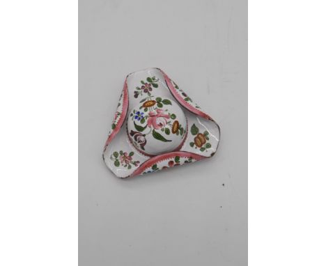 A late 19th century enamel patch box in the form of a tricorn hat, the white ground decorated with floral sprays, the base wi