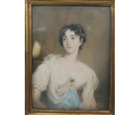 A gilt metal repousse framed and glazed 19th century portrait minitaure on ivory of a lady in a blue dress with lace shawl. U