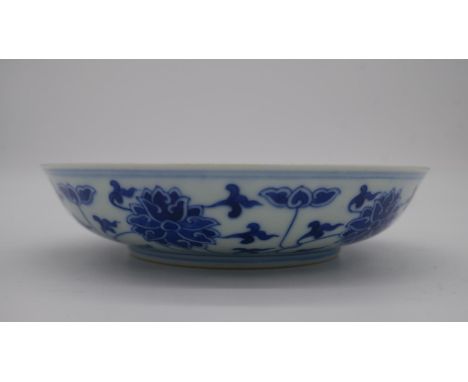 A Chinese blue and white porcelain saucer dish with foliate scroll and floral decoration, six-character Tongzhi mark. 