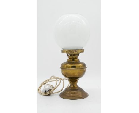 A vintage brass oil lamp with milk glass globe shade converted to electricity. H.38cm 