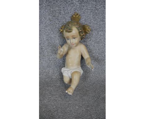 A painted ceramic model of Baby Jesus with brass halo. 