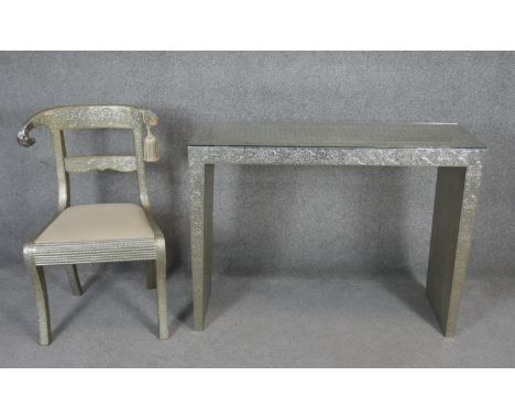 An Eastern style embossed metal clad console table and a similar bar back dining chair on sabre supports. H.80 W.105 D.35cm (